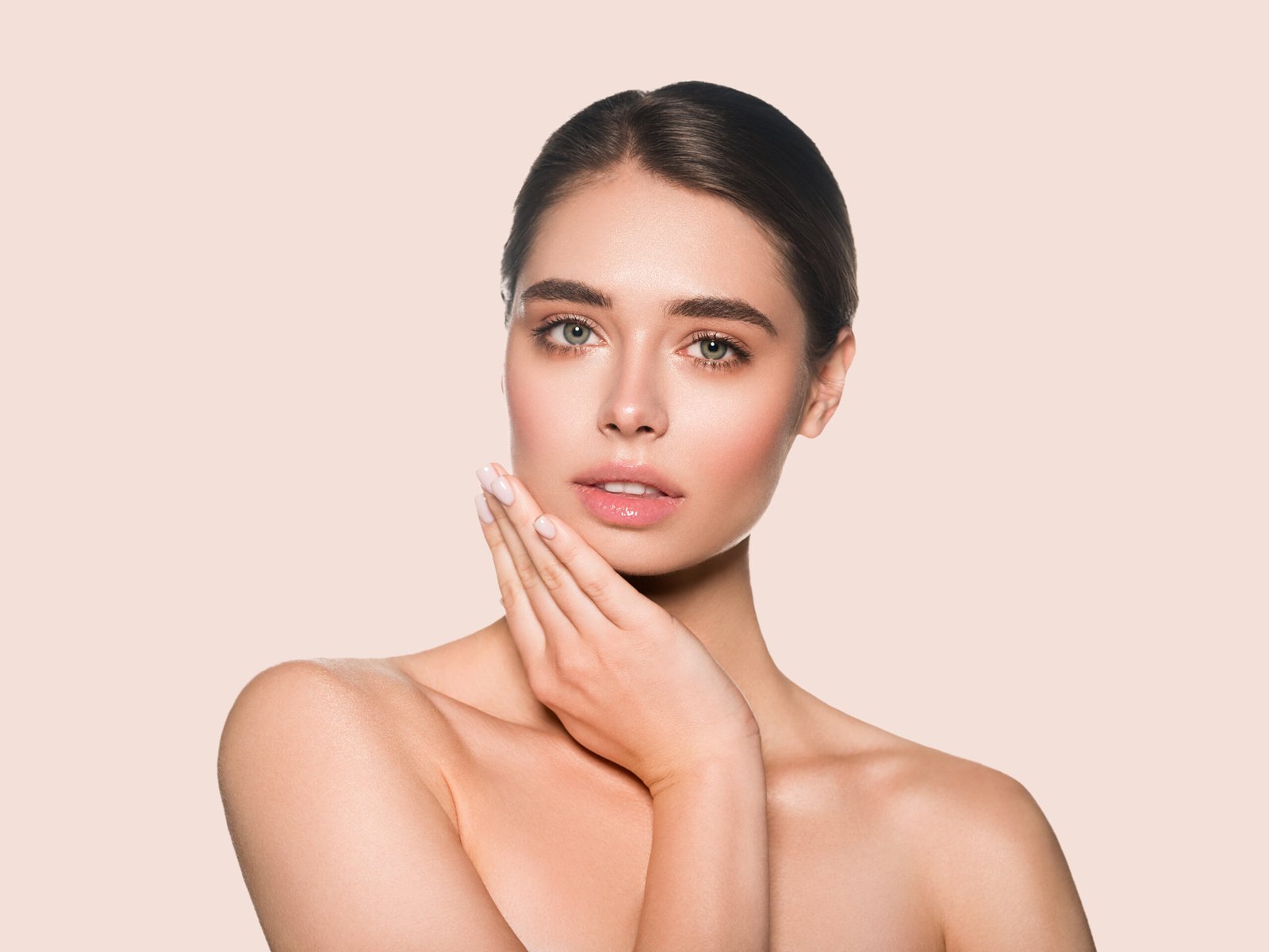 Natural smiling brunette make up woman beauty cosmetic touching her face. Color background. Pink